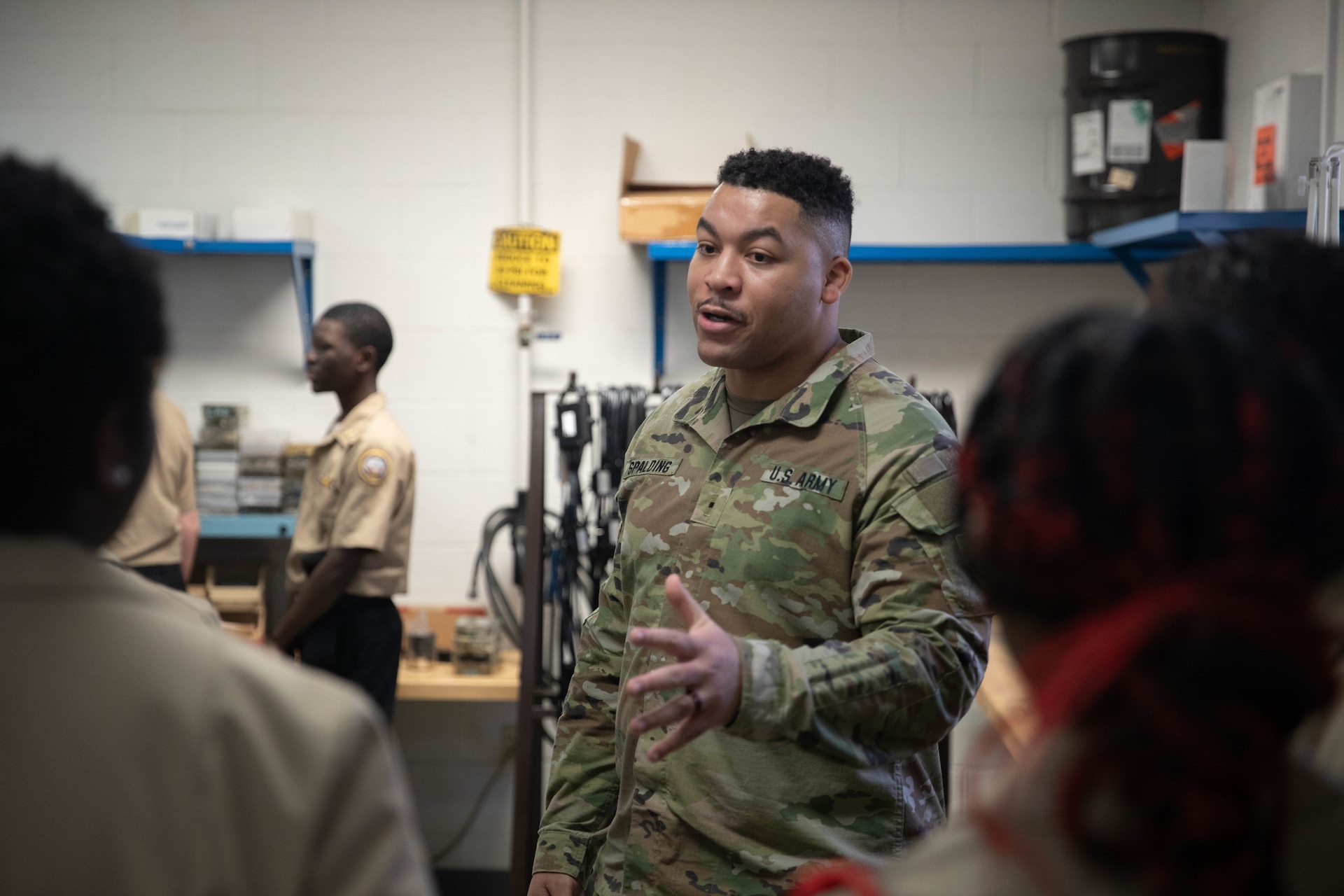 Warrant Officer Jason Spalding speaks to students with the Shawnee Academy’s JROTC program prior to their tour of the Kentucky Army National Guard’s Maneuver Area Training Equipment Site (MATES) at Fort Knox, Mar. 12. The students took part in a hands-on tour of the facilities. They explored maintenance shops, logistics areas, and got up close with military equipment. (U.S. Army National Guard photo by Milt Spalding)