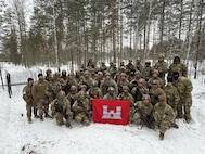 Virginia National Soldiers assigned to the 237th Engineer Company, 276th Engineer Battalion, 329th Regional Support Group, stand together in front of the ‘Eleven Row’ anti-vehicle obstacle they constructed to demonstrate U.S. counter-mobility tactics for Finland’s Kymi Engineer Battalion.