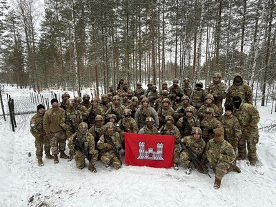 Virginia National Soldiers assigned to the 237th Engineer Company, 276th Engineer Battalion, 329th Regional Support Group, stand together in front of the ‘Eleven Row’ anti-vehicle obstacle they constructed to demonstrate U.S. counter-mobility tactics for Finland’s Kymi Engineer Battalion.