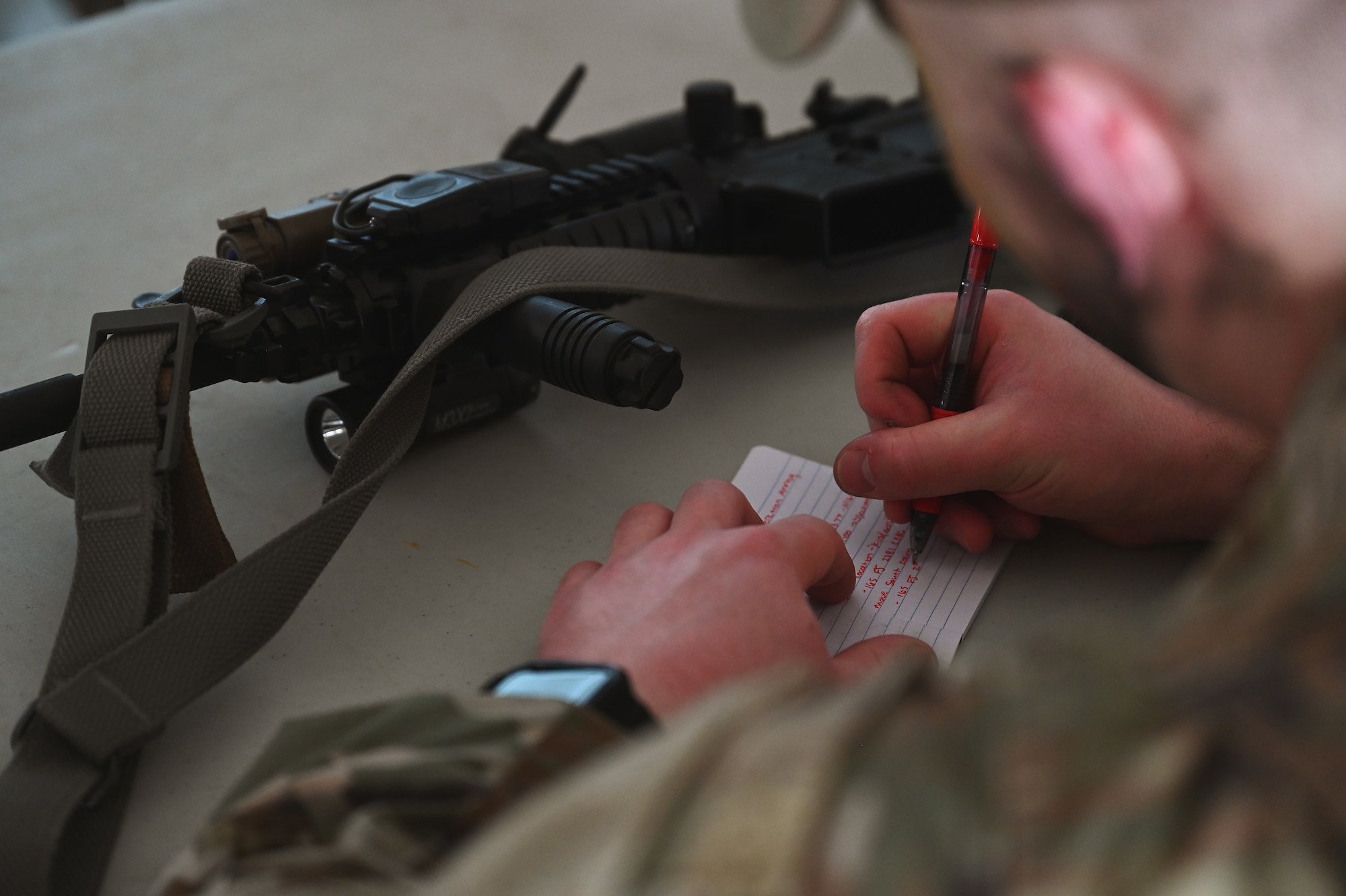 A U.S. Airman assigned to the 178th Security Forces Squadron, Ohio Air National Guard takes notes during a mission briefing Feb. 3, 2025 while attending annual training at Camp Holland in Butlerville, Indiana. The training focused on ways to identify how to minimize equipment and personnel footprints to increase dispersal capabilities and complicate adversary targeting. (U.S. Air National Guard photo by Shane Hughes)