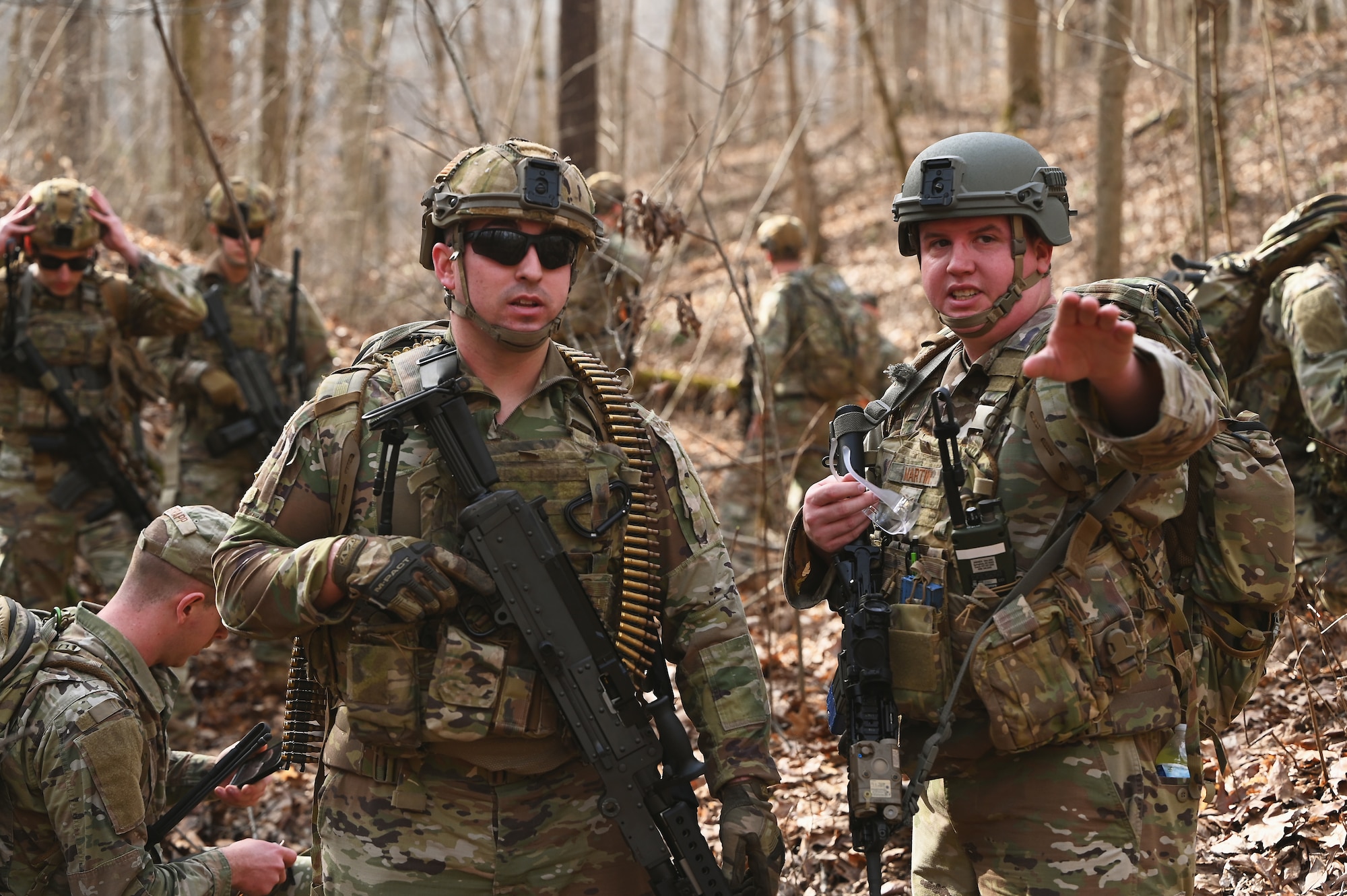 U.S. Airmen assigned to the 178th Security Forces Squadron, Ohio Air National Guard discuss the advantages and disadvantages of possible defensive fighting positions after locating their mission objective Feb. 3, 2025 during annual training at Camp Holland in Butlerville, Indiana. The training, primarily focused on mission planning, included attacking and defending positions and aligning tactics with the Air Force doctrine of Agile Combat Employment. (U.S. Air National Guard photo by Shane Hughes)