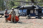 Virginia National Guard aviation crews assigned to the 2nd Battalion, 224th Aviation Regiment, 29th Infantry Division, train on aerial fire suppression with UH-60 Black Hawk helicopters equipped with water buckets March 12, 2025, during a prescribed burn at Fort Barfoot, Virginia.