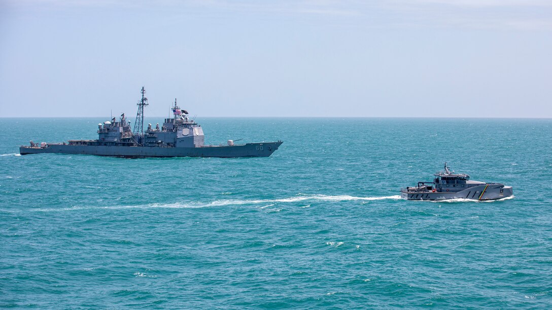 The Ticonderoga-class guided-missile cruiser USS Normandy (CG 60) conducts a passing exercise with Guyana Defense Force Defiant-class patrol ship GDSF Shahoud in the Caribbean Sea, March 27, 2025. Normandy is scheduled to protect U.S. interests in the region and strengthen maritime partnerships through bilateral and multinational maritime operations and Theater Security Cooperation port visits. U.S. Naval Forces Southern Command/U.S. 4th Fleet is the maritime component of U.S. Southern Command and the trusted maritime partner for Caribbean, Central, and South American maritime forces, leading to improved unity, security, and stability. (U.S. Navy photo by Mass Communication Specialist 2nd Class Dylan M. Kinee/Released)