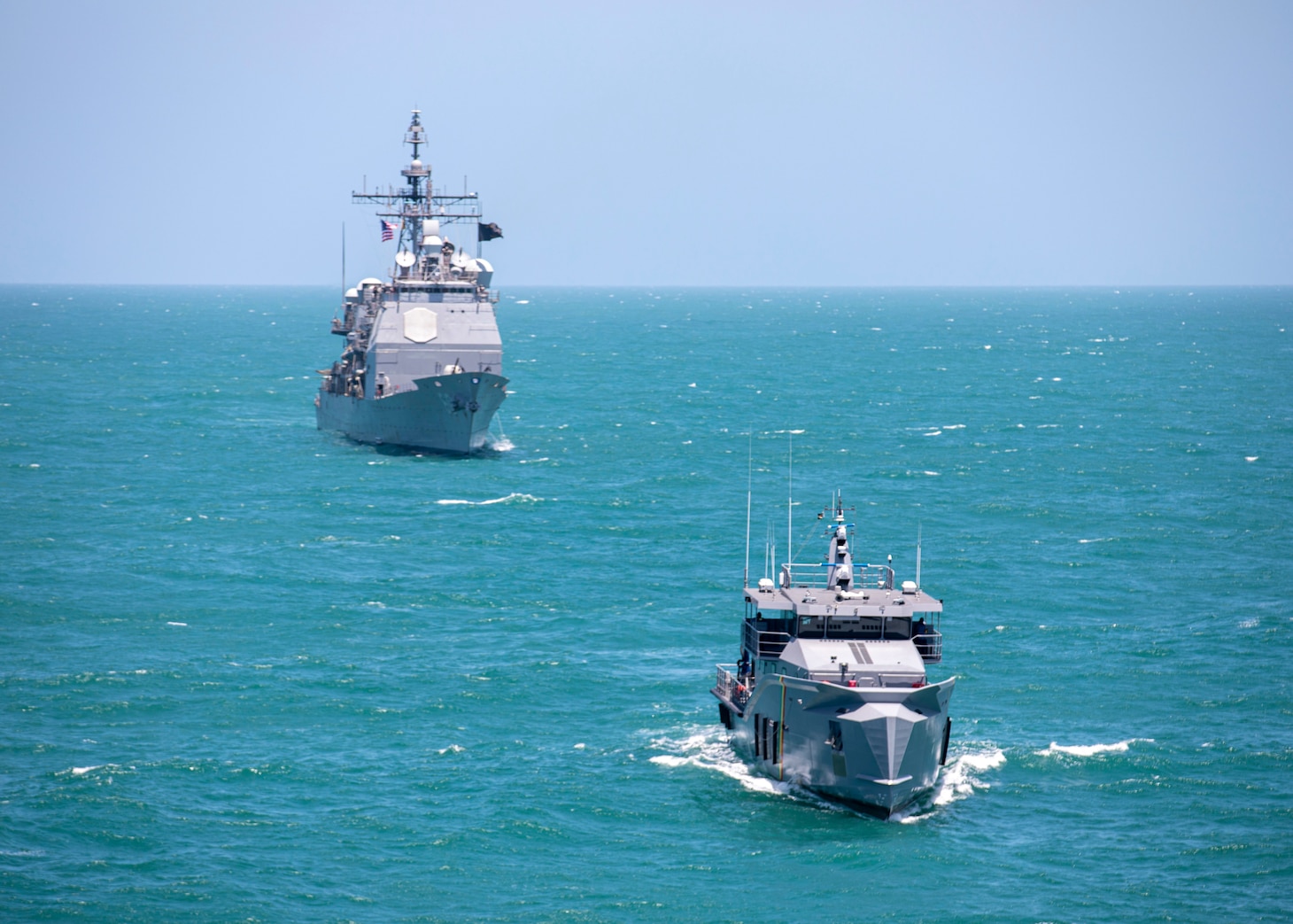 The Ticonderoga-class guided-missile cruiser USS Normandy (CG 60) conducts a passing exercise with Guyana Defense Force Defiant-class patrol ship GDSF Shahoud in the Caribbean Sea, March 27, 2025. Normandy is scheduled to protect U.S. interests in the region and strengthen maritime partnerships through bilateral and multinational maritime operations and Theater Security Cooperation port visits. U.S. Naval Forces Southern Command/U.S. 4th Fleet is the maritime component of U.S. Southern Command and the trusted maritime partner for Caribbean, Central, and South American maritime forces, leading to improved unity, security, and stability. (U.S. Navy photo by Mass Communication Specialist 2nd Class Dylan M. Kinee/Released)
