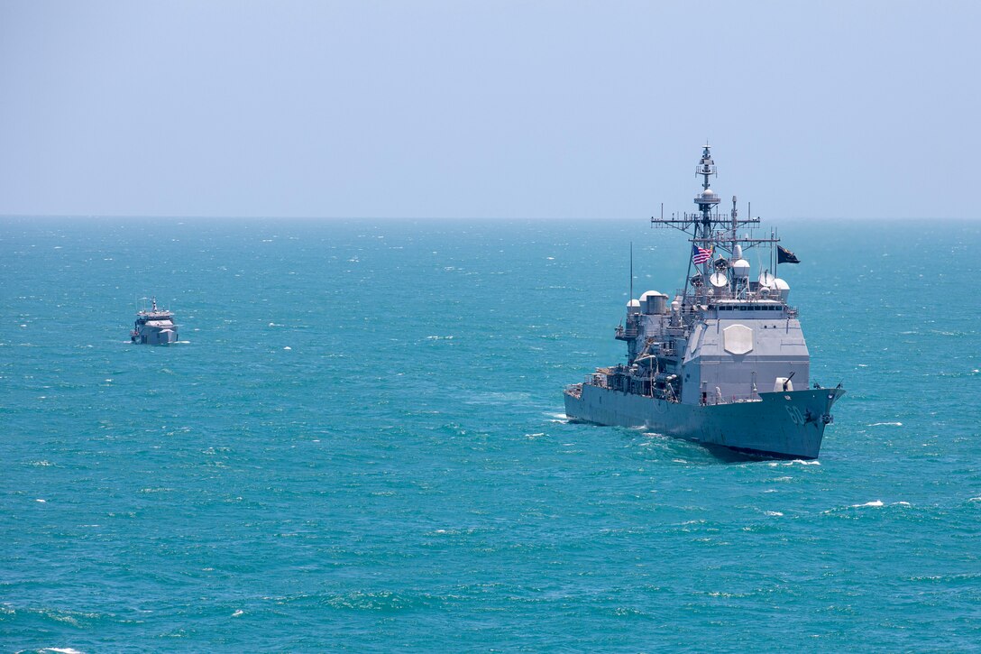 The Ticonderoga-class guided-missile cruiser USS Normandy (CG 60) conducts a passing exercise with Guyana Defense Force Defiant-class patrol ship GDSF Shahoud in the Caribbean Sea, March 27, 2025. Normandy is scheduled to protect U.S. interests in the region and strengthen maritime partnerships through bilateral and multinational maritime operations and Theater Security Cooperation port visits. U.S. Naval Forces Southern Command/U.S. 4th Fleet is the maritime component of U.S. Southern Command and the trusted maritime partner for Caribbean, Central, and South American maritime forces, leading to improved unity, security, and stability. (U.S. Navy photo by Mass Communication Specialist 2nd Class Dylan M. Kinee/Released)