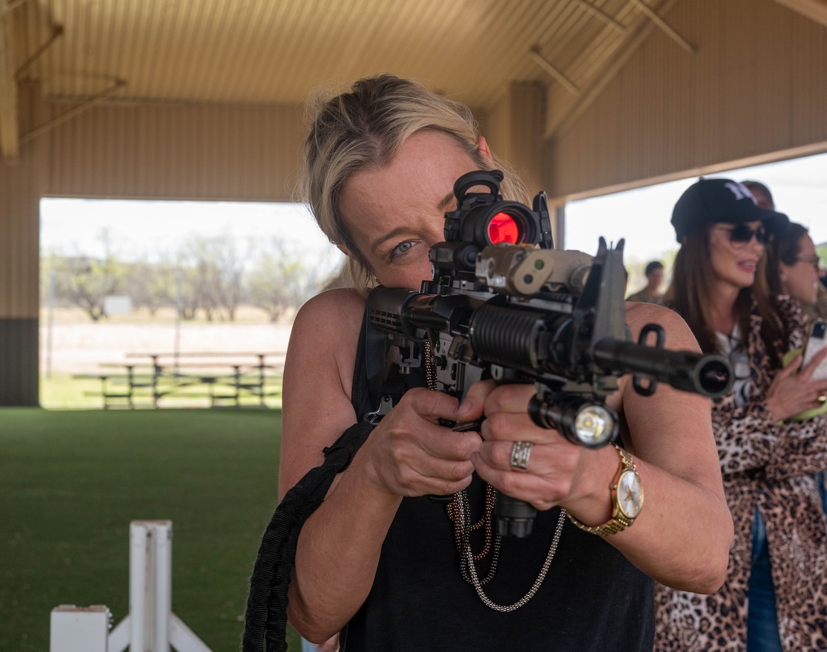 Andi Markee, 17th Training Wing honorary commander, aims down sight with an M4 carbine during a weapons demonstration at Goodfellow Air Force Base, Texas, March 27, 2025. Airmen are required to qualify on the M4 during Basic Training and continue to maintain proficiency throughout their military careers. (U.S. Air Force photo by Senior Airman Zach Heimbuch)