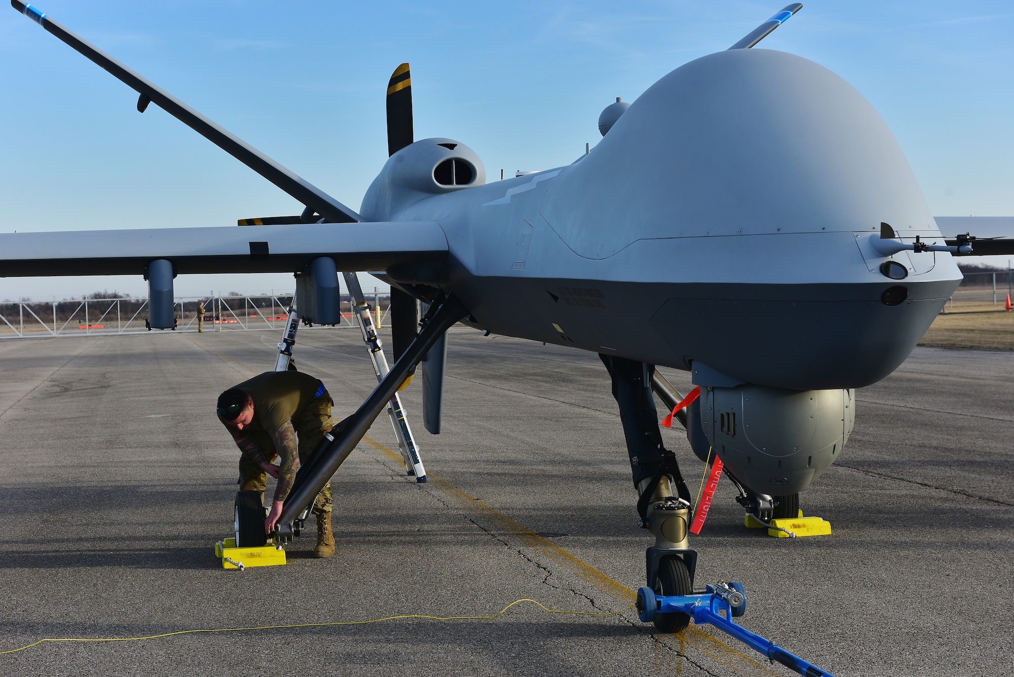 A U.S. Air Force crew chief assigned to the174th Attack Wing, performs post-flight maintenance on an MQ-9 Reaper on Mar. 10, 2025  at Springfield-Beckley Air National Guard Base in Springfield, Ohio. The MQ-9 arrived for Advanced Wrath, a two-week exercise supporting U.S. Special Operations Command, U.S. Coast Guard search and rescue operations, and testing for the Air Force Research Laboratory. (U.S. Air National Guard photo by Shane Hughes)