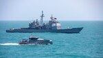 The Ticonderoga-class guided-missile cruiser USS Normandy (CG 60) conducts a passing exercise with Guyana Defense Force Defiant-class patrol ship GDSF Shahoud in the Caribbean Sea, March 27, 2025. Normandy is scheduled to protect U.S. interests in the region and strengthen maritime partnerships through bilateral and multinational maritime operations and Theater Security Cooperation port visits. U.S. Naval Forces Southern Command/U.S. 4th Fleet is the maritime component of U.S. Southern Command and the trusted maritime partner for Caribbean, Central, and South American maritime forces, leading to improved unity, security, and stability. (U.S. Navy photo by Mass Communication Specialist 2nd Class Dylan M. Kinee/Released)