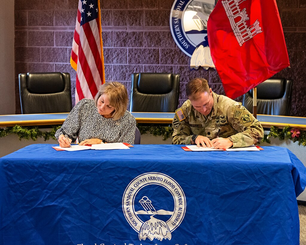 Lt. Col. Matthew Miller, left, commander, USACE-Albuquerque District, and Cassandra D’Antonio, right, chairperson, SSCAFCA board of directors, sign a Project Partnership Agreement (PPA) at the SSCAFCA office in Rio Rancho, N.M., Dec. 16, 2024.