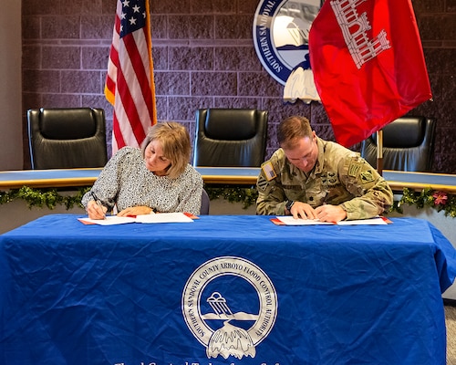 Lt. Col. Matthew Miller, left, commander, USACE-Albuquerque District, and Cassandra D’Antonio, right, chairperson, SSCAFCA board of directors, sign a Project Partnership Agreement (PPA) at the SSCAFCA office in Rio Rancho, N.M., Dec. 16, 2024.