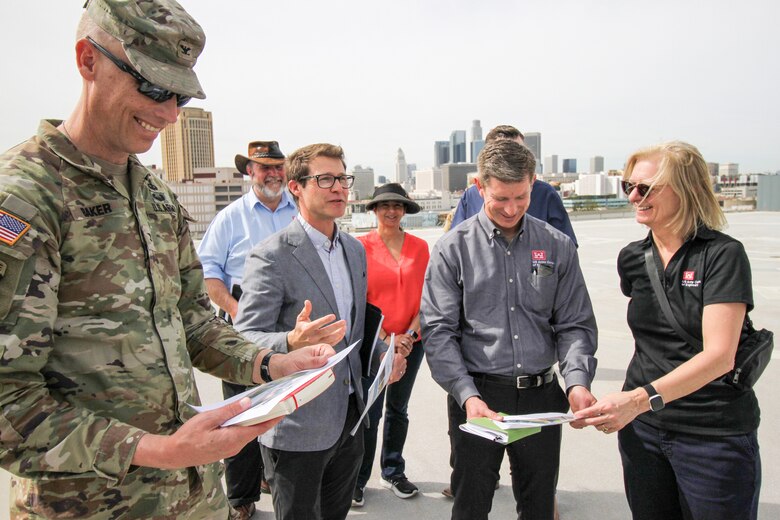 Robyn Colosimo, senior official performing the duties of the assistant secretary of the Army for Civil Works, right, receives a briefing on the LA River Ecosystem Restoration Project from Edward Belden, LA River Ecosystem Restoration project manager for the City of LA, third from left, as she gets an advantageous view of Reach 8 of the river from a helipad at the LA Transportation Center located downtown. Reach 8 of the LA River is a mile-long portion that begins at Main Street Bridge and extends downstream to the 1st Street Bridge. Reach 8 restoration components include some features that are on LATC property, and some that are not.