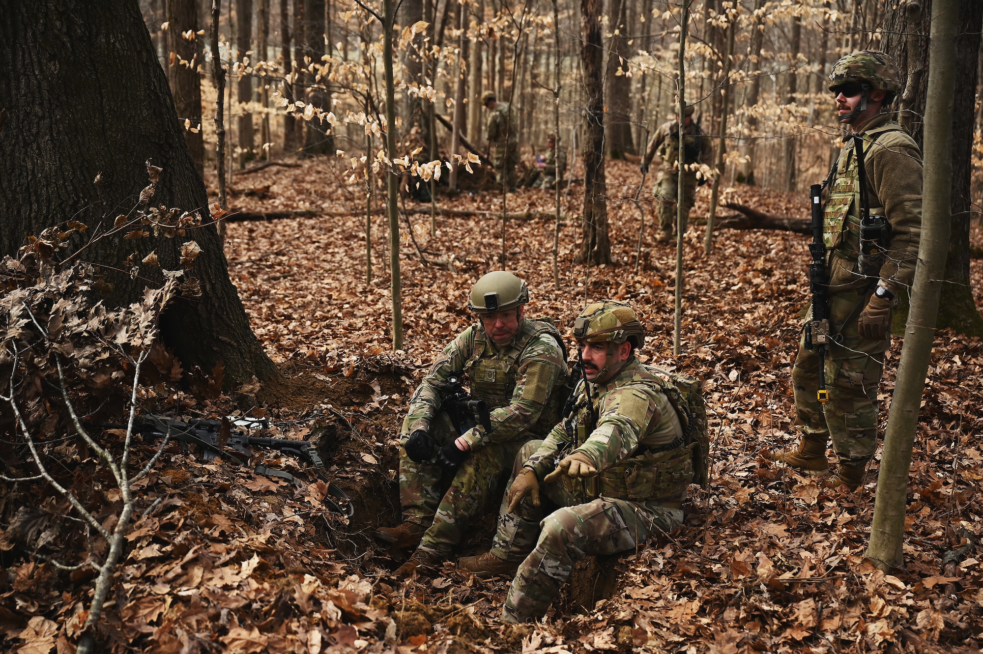 U.S. Airmen assigned to the 178th Security Forces Squadron, Ohio Air National Guard discuss the advantages and disadvantages of possible defensive fighting positions after locating their mission objective Feb. 4, 2025 during annual training at Camp Holland in Butlerville, Indiana. The training, primarily focused on mission planning, included attacking and defending positions and aligning tactics with the Air Force doctrine of Agile Combat Employment. (U.S. Air National Guard photo by Shane Hughes)