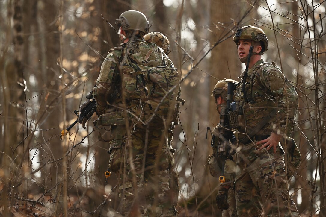 U.S. Airmen assigned to the 178th Security Forces Squadron, Ohio Air National Guard discuss the advantages and disadvantages of possible defensive fighting positions after locating their mission objective Feb. 3, 2025 during annual training at Camp Holland in Butlerville, Indiana. The training, primarily focused on mission planning, included attacking and defending positions and aligning tactics with the Air Force doctrine of Agile Combat Employment. (U.S. Air National Guard photo by Shane Hughes)