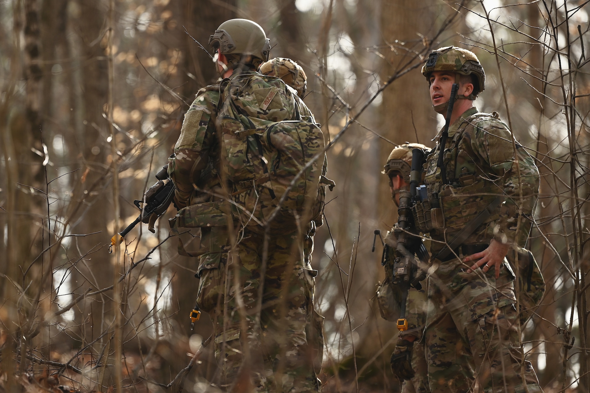 U.S. Airmen assigned to the 178th Security Forces Squadron, Ohio Air National Guard discuss the advantages and disadvantages of possible defensive fighting positions after locating their mission objective Feb. 3, 2025 during annual training at Camp Holland in Butlerville, Indiana. The training, primarily focused on mission planning, included attacking and defending positions and aligning tactics with the Air Force doctrine of Agile Combat Employment. (U.S. Air National Guard photo by Shane Hughes)