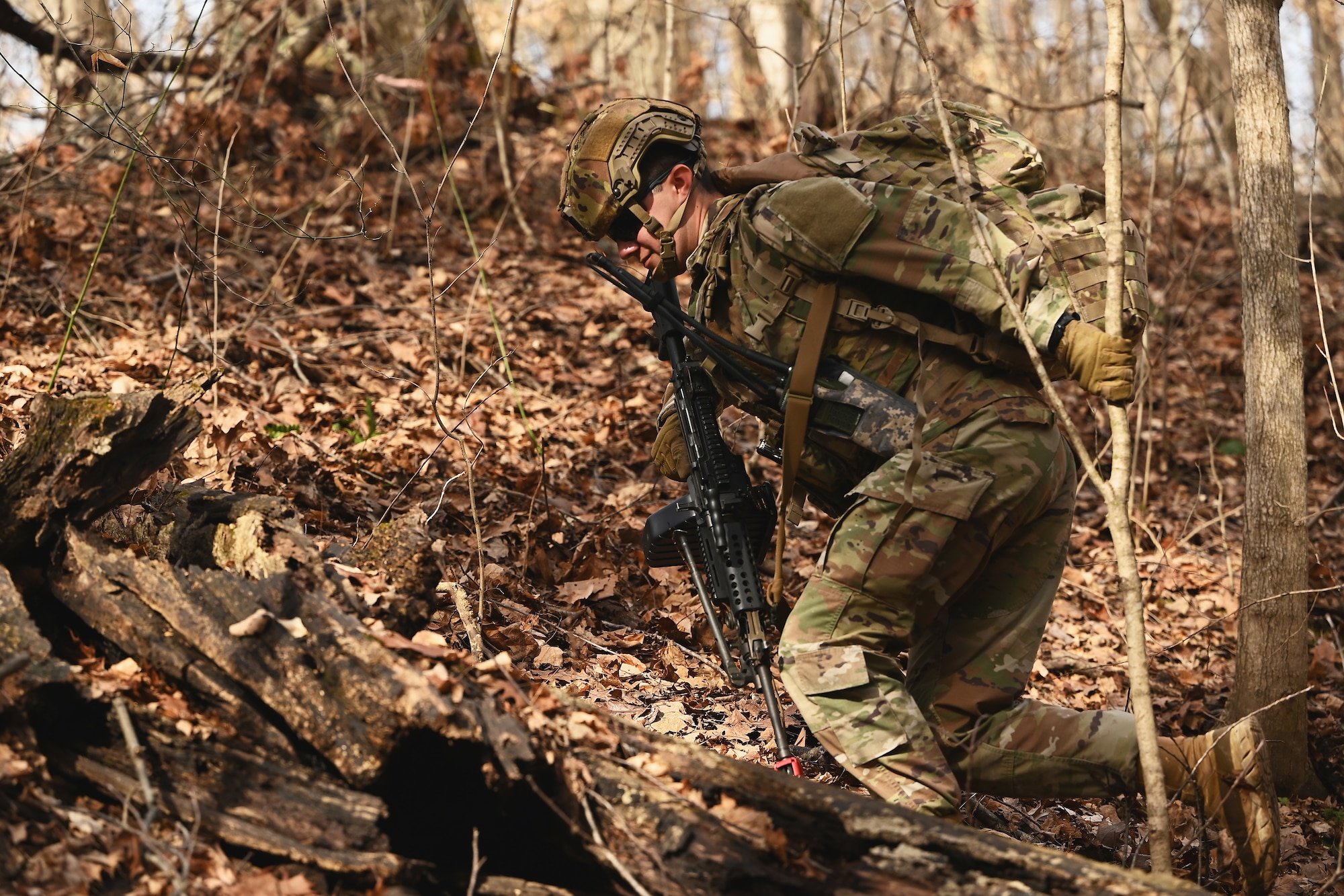 A U.S. Airmen assigned to the 178th Security Forces Squadron, Ohio Air National Guard moves to a new fighting position during a simulated enemy attack Feb. 3, 2025 while at annual training at Camp Holland in Butlerville, Indiana. The training, primarily focused on mission planning, included attacking and defending positions and aligning tactics with the Air Force doctrine of Agile Combat Employment. (U.S. Air National Guard photo by Shane Hughes)