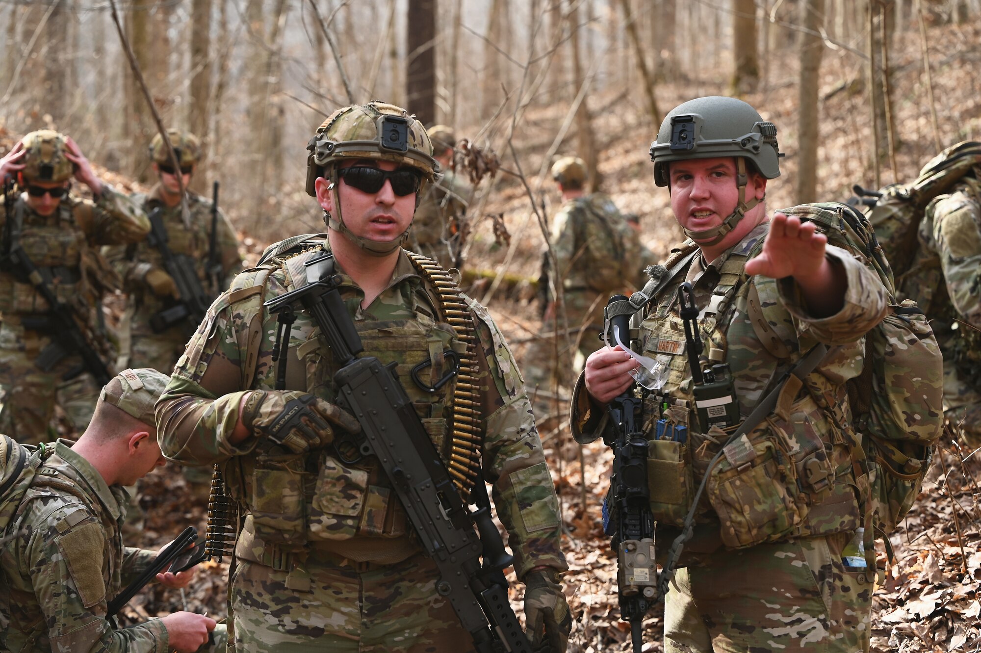 U.S. Airmen assigned to the 178th Security Forces Squadron, Ohio Air National Guard discuss the advantages and disadvantages of possible defensive fighting positions after locating their mission objective Feb. 3, 2025 during annual training at Camp Holland in Butlerville, Indiana. The training, primarily focused on mission planning, included attacking and defending positions and aligning tactics with the Air Force doctrine of Agile Combat Employment. (U.S. Air National Guard photo by Shane Hughes)