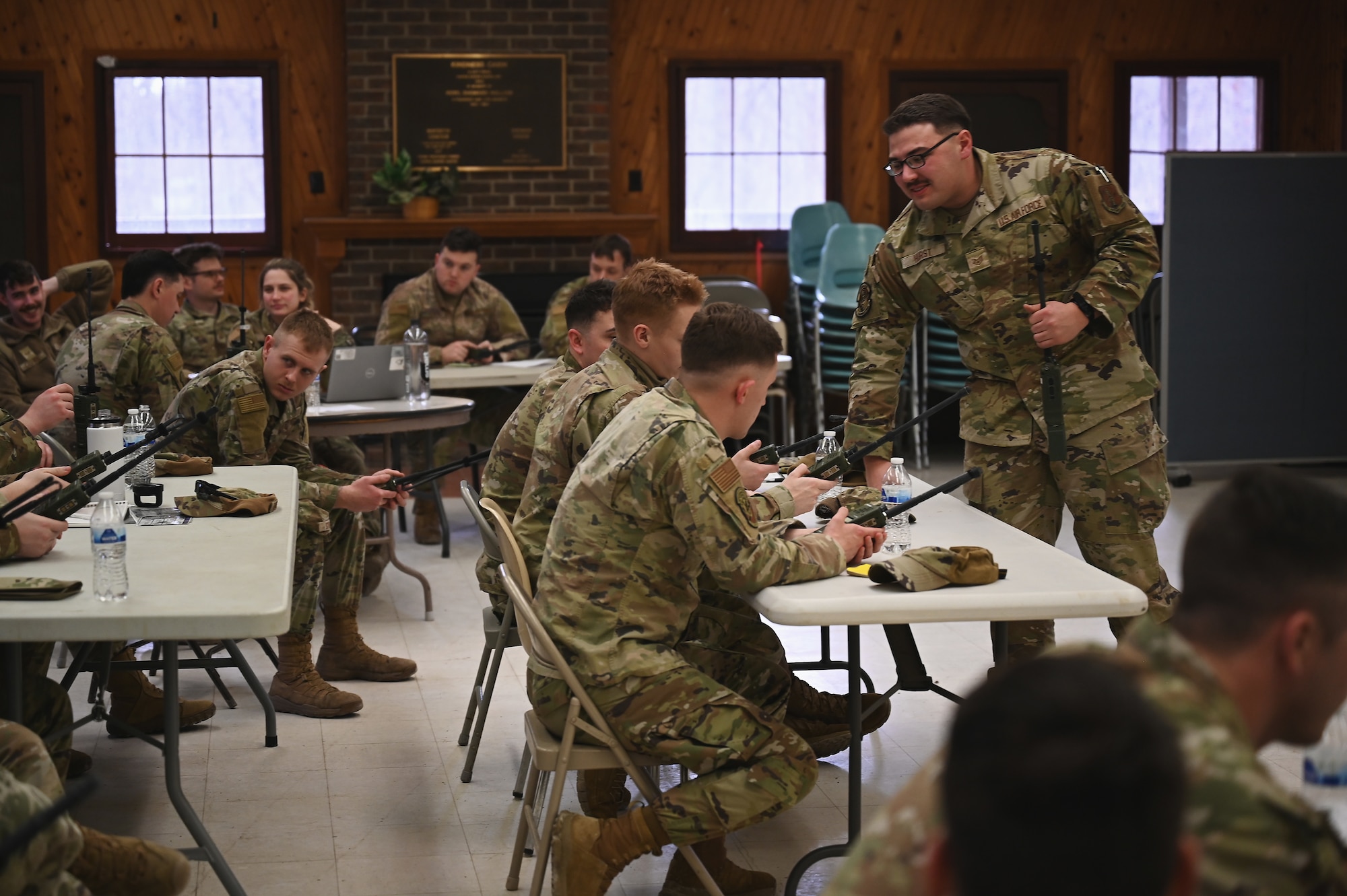 U.S. Air Force Staff Sgt. Joshua Hurst, a radio frequency transmissions specialist assigned to the 178th Wing, Ohio Air National Guard, teaches a class on radio communications basics to 20 airmen from the 178th Security Forces Squadron on Feb. 2, 2025 during an annual training exercise at Camp Holland in Butlerville, Indiana. The training focused on building the expeditionary skills necessary to operate outside of  enduring locations. (U.S. Air National Guard photo by Shane Hughes)