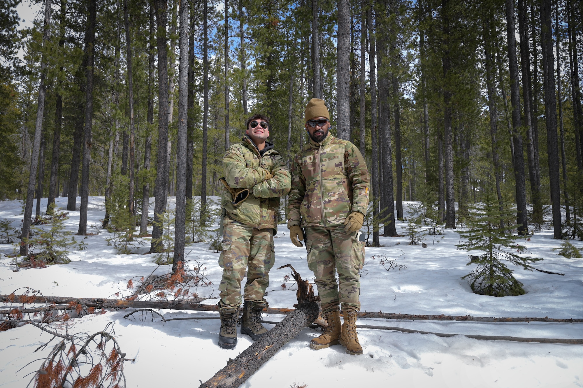 Two men in military uniform stand shoulder to shoulder in center frame.