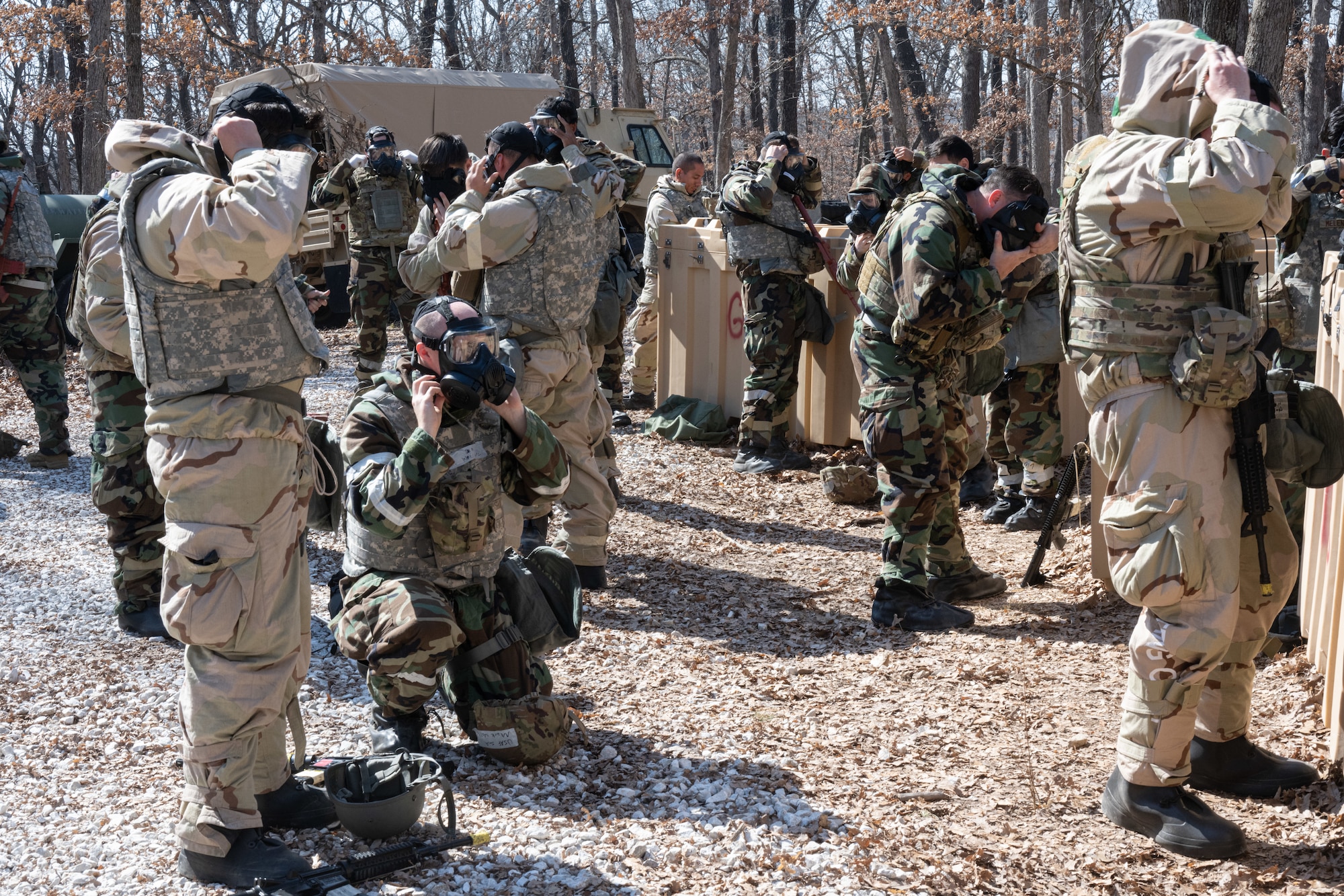 Airmen from the 509th Bomb wing remove their mission oriented protective posture gear during a field training exercise in Macon, Mo., March 13, 2025. The exercise tested warfighter readiness by simulating austere environments and complex enemy engagements, pushing participants to adapt and overcome challenges. (U.S. Air Force photo by Senior Airman Bryson Sherard)