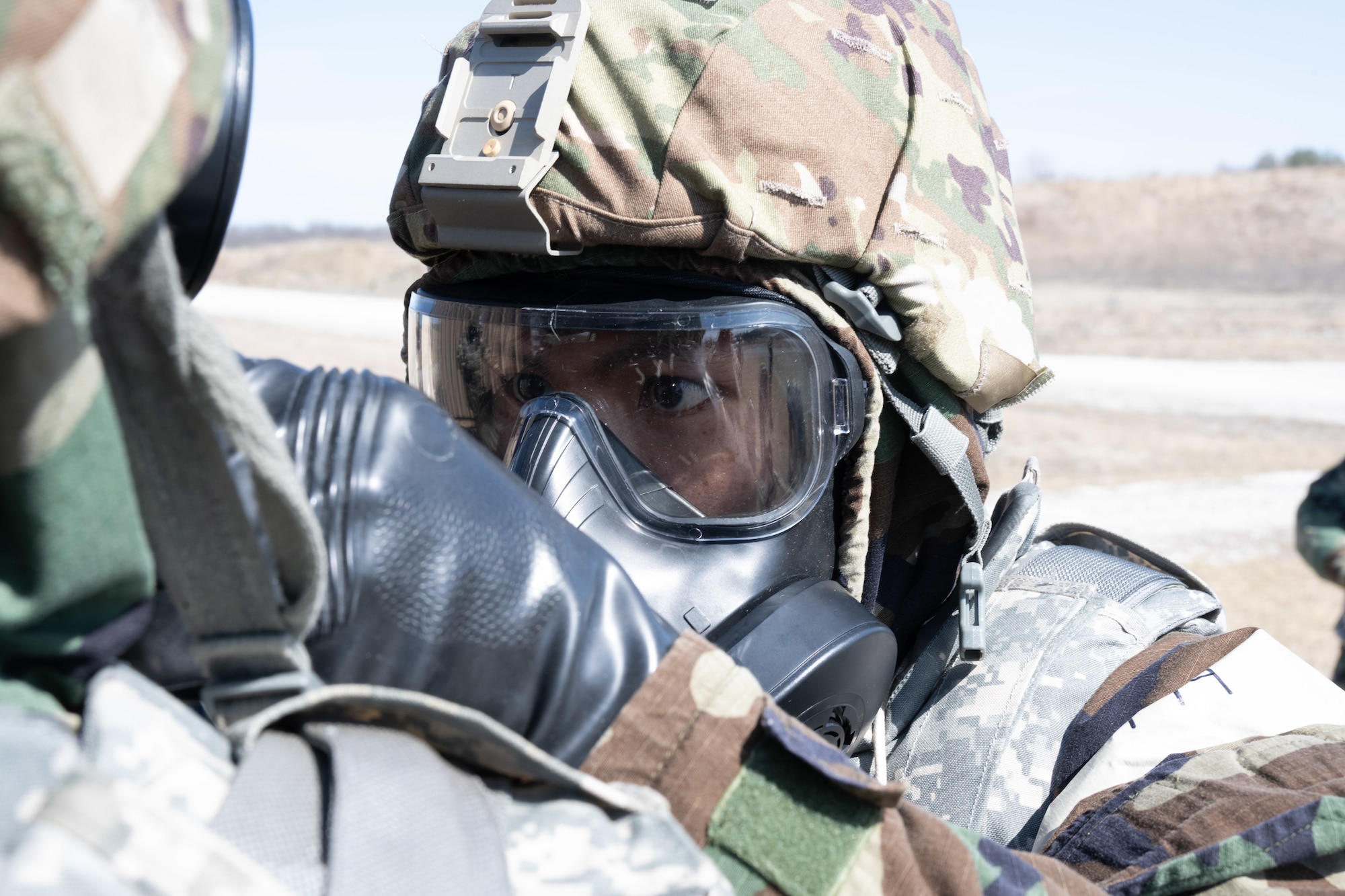 Staff Sgt. Eddie Tang-Chau, 509th medical group noncommissioned officer in charge for the environmental health element, performs a buddy check of another Airmen's mission oriented protective posture gear during a field training exercise in Macon, Mo., March 12, 2025. The exercise tested warfighter readiness by simulating austere environments and complex enemy engagements, pushing participants to adapt and overcome challenges. (U.S. Air Force photo by Senior Airman Bryson Sherard)
