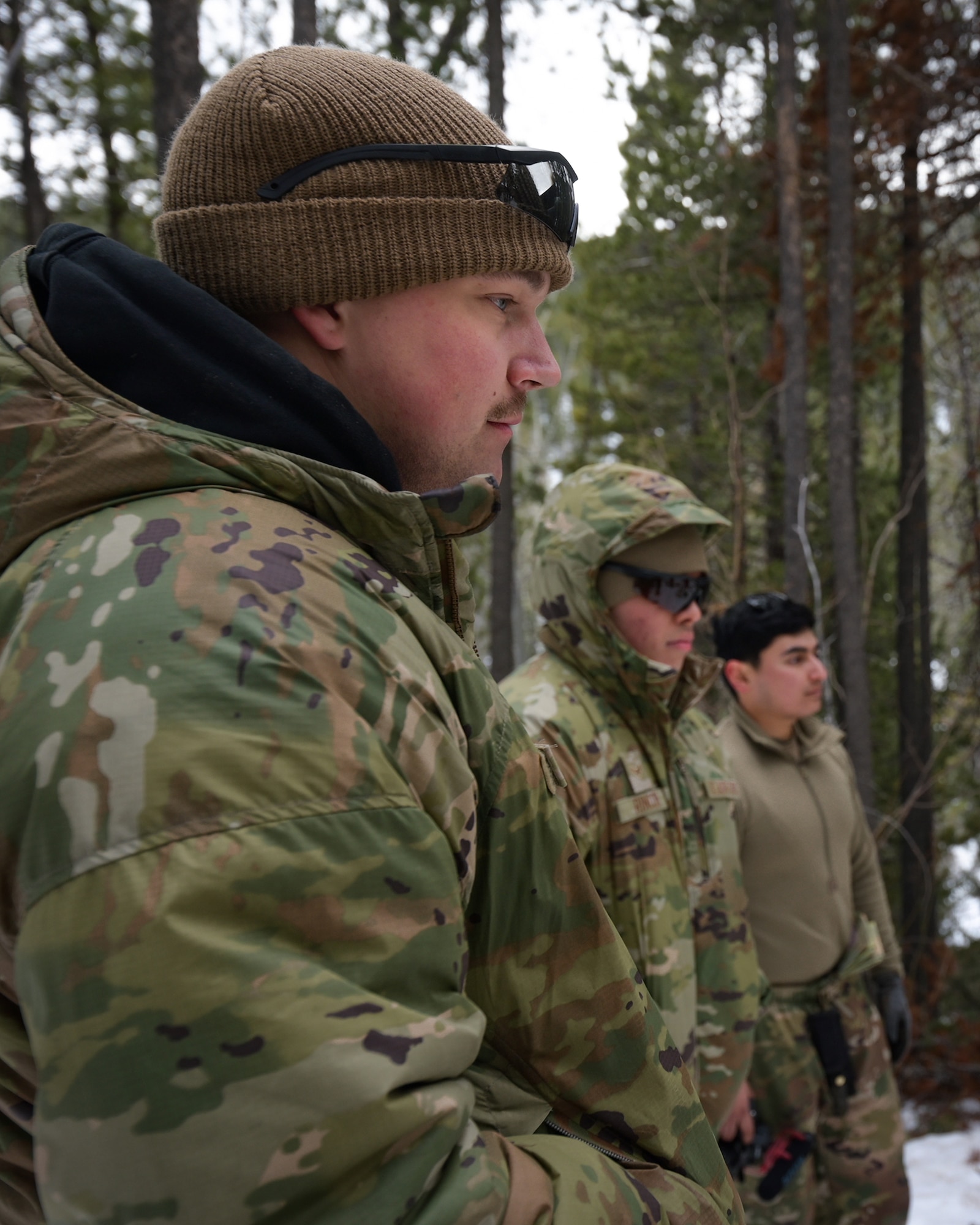 Three men in military uniform look right of frame.