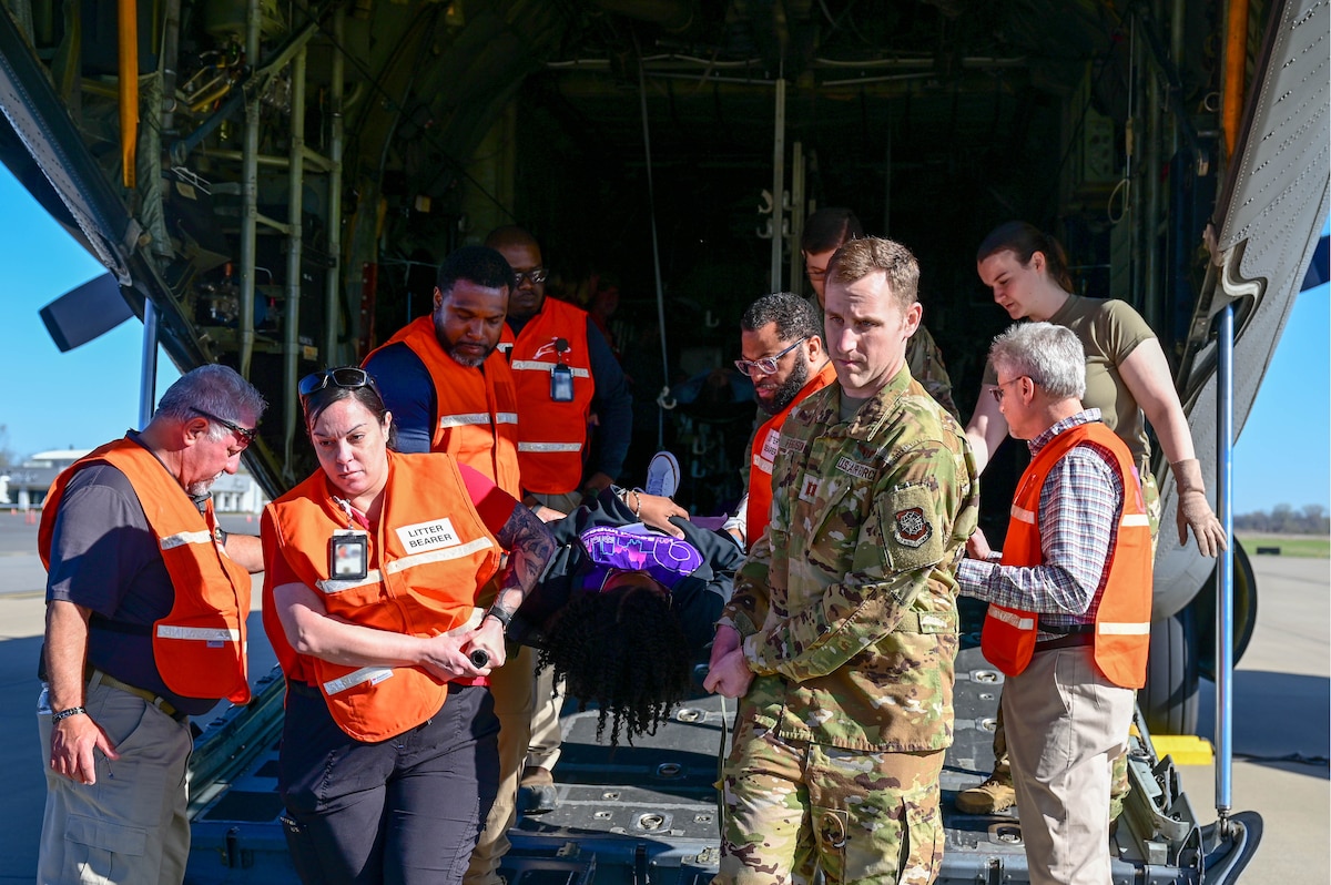 People offload a patient from a plane.