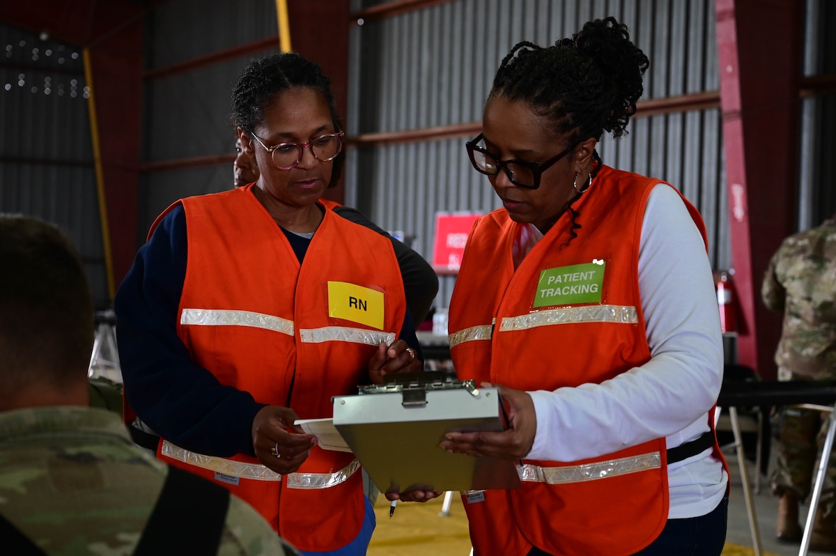 Two women look at a clipboard.