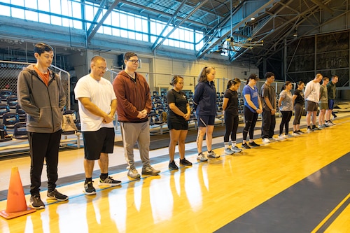 Participants observe a moment of silence for fallen Airmen before the start of the Memorial Workout Initiative at Maxwell Air Force Base, Alabama, on March 28, 2025.