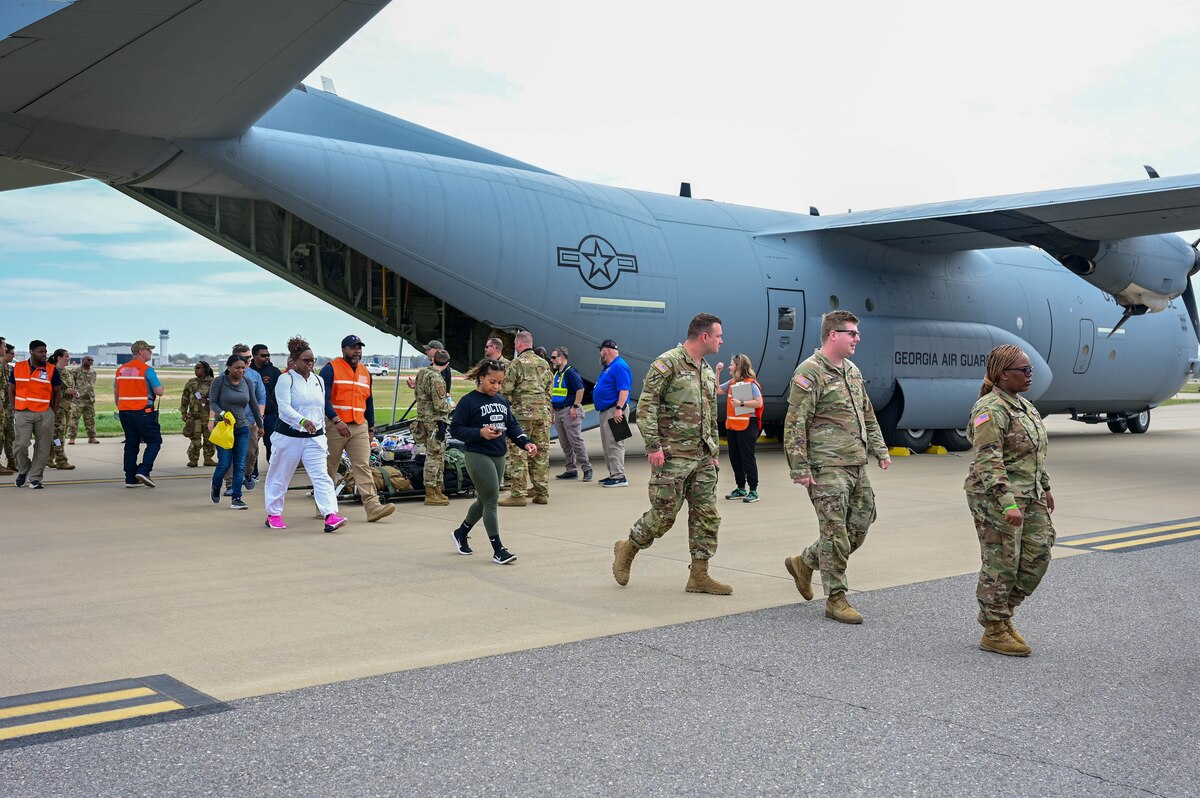 People walk from a plane.