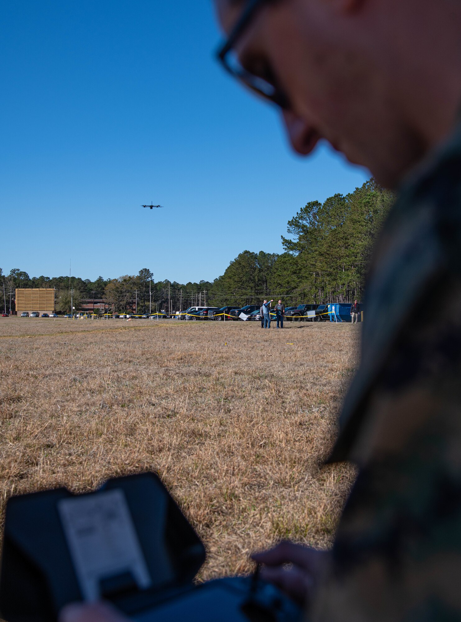 Marine looking at a system with a drone hovering in the background.