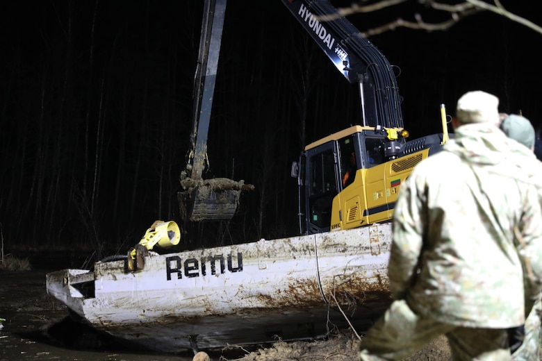 An excavator removes silt and debris as Lithuanian Armed Forces personnel and emergency services work through the night  during recovery efforts for a U.S. Army M88 Hercules recovery vehicle submerged under several meters of water in a swamp near a training area in Pabradė, Lithuania, March 28, 2025.(U.S. Army photo by Staff Sgt. Rose Di Trolio)