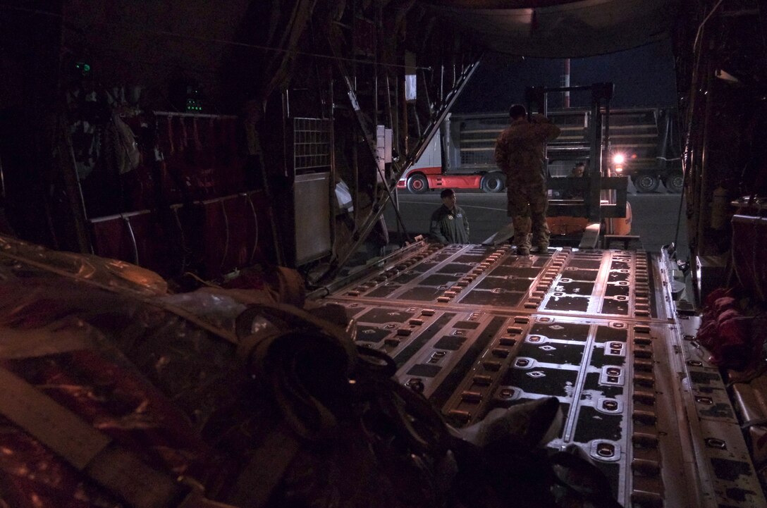 U.S. Air Force members from 37th Airlift Squadron work late into the night to unload diving equipment from a U.S. Air Force C-130 Hercules aircraft at Vilnius International Airport to be used in the ongoing efforts to find four U.S. soldiers in a submerged M88 Hercules on a training site near Pabadre, Lithuania on March 29, 2025.