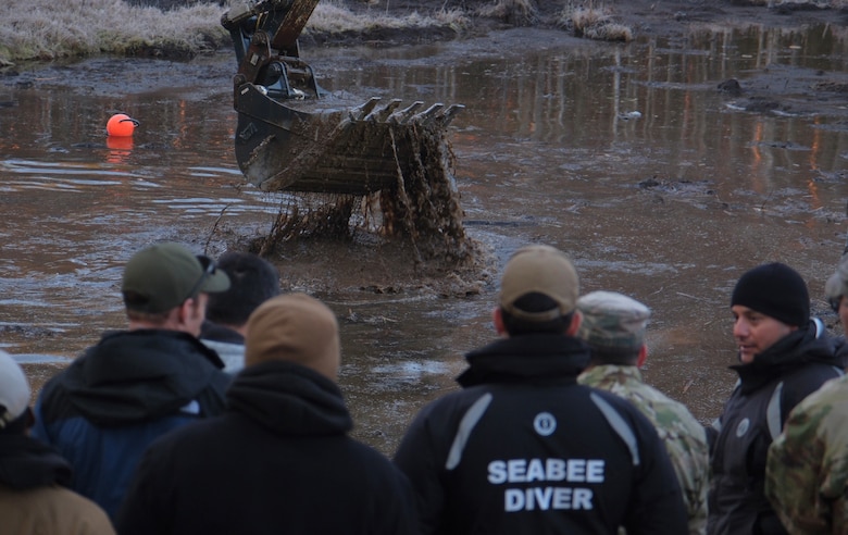 Members of Commader, Task Force (CTF) 68 U.S. Navy dive team arrive on site to assess diving operations to recover four U.S. soldiers in a submerged M88 Hercules on a training site near Pabadre, Lithuania on March 29, 2025.
