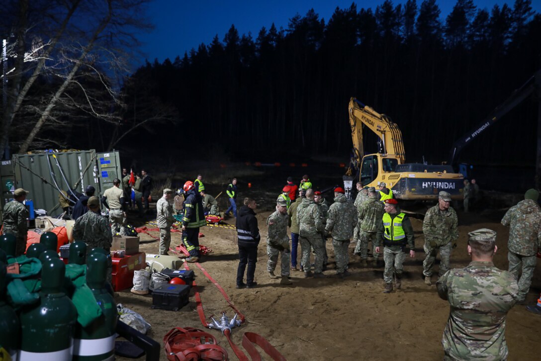 Members of Commander, Task Force (CTF) 68, a U.S. Navy dive team, begin diving operations in support of efforts to find four U.S. soldiers in a submerged M88 Hercules recovery vehicle at a training site near Pabradė, Lithuania, March 29, 2025.
