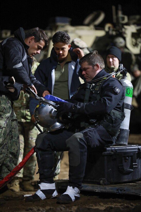 Members of Commander, Task Force (CTF) 68, a U.S. Navy dive team, begin diving operations in support of efforts to find four U.S. soldiers in a submerged M88 Hercules recovery vehicle at a training site near Pabradė, Lithuania, March 29, 2025.