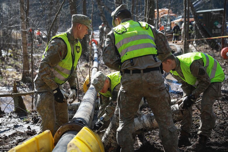Lithuanian Armed Forces assist U.S. Army soldiers and emergency services in the recovery operation of a submerged M88 Hercules recovery vehicle by setting up a water pump pipe line near Pabradė, Lithuania, March 29, 2025.