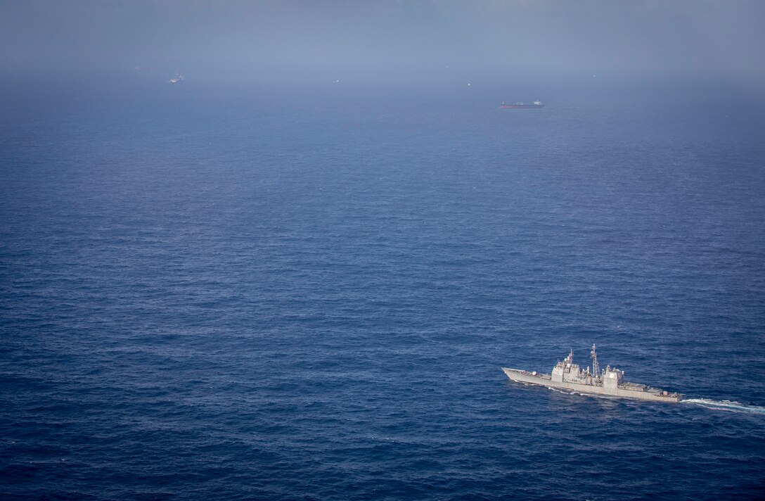 U.S. Navy Ticonderoga-class guided-missile cruiser USS Normandy (CG 60) passes floating production, storage, and offloading (FPSO) vessels supporting Guyana's energy development in the Stabroek Block off the coast of Guyana in the North Atlantic Ocean, March 27, 2025. Normandy is scheduled to protect U.S. interests in the region and strengthen maritime partnerships through bilateral and multinational maritime operations and Theater Security Cooperation (TSC) port visits. U.S. Naval Forces Southern Command/U.S. 4th Fleet is the maritime component of U.S. Southern Command and the trusted maritime partner for Caribbean, Central, and South American maritime forces leading to improved unity, security, and stability. (U.S. Navy photo by Mass Communication Specialist 2nd Class Dylan M. Kinee/Released)