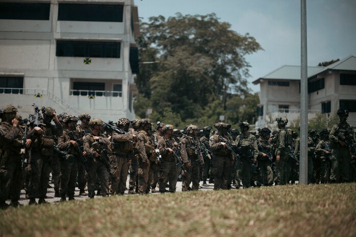 U.S. Marines with 1st Battalion, 5th Marine Regiment, 1st Marine Division, attached to Marine Rotational Force-Southeast Asia, alongside Singapore Guardsmen with 3rd Battalion Singapore Guards, 7th Singapore Infantry Brigade, stand-by for the closing ceremony for Valiant Mark 25 at SAFTI City training facility, Singapore, March 27, 2025.