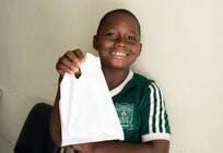 A young island resident smiles for a photo as he holds a dental hygiene kit provided by U.S. Air Force dental personnel during the Lesser Antilles Medical Assistance Team (LAMAT) 2025 mission at Celina Clouden Smart Hospital, Union Island, Saint Vincent and the Grenadines, March 20, 2025.