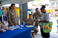 U.S. Air Force medical professionals distribute oral hygiene kits to a local resident during the Lesser Antilles Medical Assistance Team (LAMAT) 2025 health fair at Kingstown, Saint Vincent and the Grenadines, March 20, 2025.