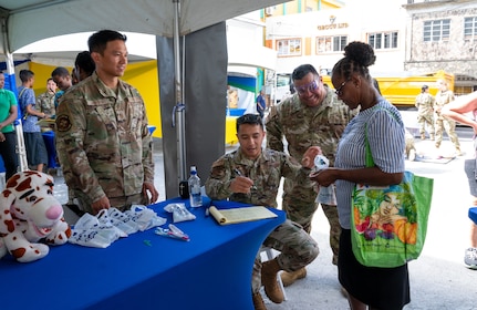U.S. Air Force medical professionals distribute oral hygiene kits to a local resident during the Lesser Antilles Medical Assistance Team (LAMAT) 2025 health fair at Kingstown, Saint Vincent and the Grenadines, March 20, 2025.