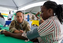 U.S. Air Force 1st Lt. Dana Macabales, 349th  Medical Squadron intensive care unit nurse, performs a blood pressure check for a local resident during the Lesser Antilles Medical Assistance Team (LAMAT) 2025 health fair at Kingstown, Saint Vincent and the Grenadines, March 20, 2025.
