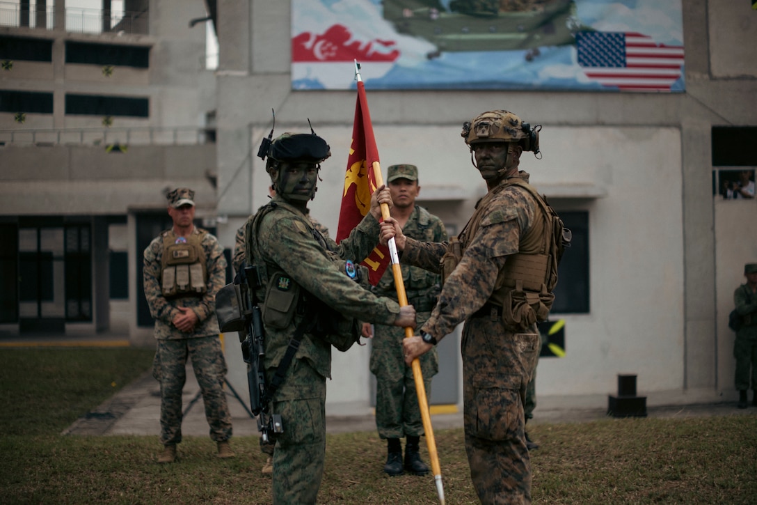 Singapore Guardsman Lt. Col. Mohamad Fahrul Bin Saaid, left, the commanding officer for 3rd Battalion Singapore Guards and U.S. Marine Corps Capt. Louis Collins, a company commander with 1st Battalion, 5th Marine Regiment, 1st Marine Division, attached to Marine Rotational Force-Southeast Asia, pose for a photo during the closing ceremony for Valiant Mark 25 at SAFTI City training facility, Singapore, March 27, 2025. SAFTI City, the premier urban training facility in Southeast Asia, is one of the largest and most technologically advanced facilities of its kind in the world. U.S. Marines with MRF-SEA were the first foreign partner force to train at the facility during Valiant Mark 25. Valiant Mark is an annual, bilateral training exercise designed to enhance interoperability, build mutual defense capabilities, and strengthen military-to-military relationships between the U.S. Marine Corps and Singapore Armed Forces. MRF-SEA is a rotational unit derived from elements of I MEF executing a U.S. Marine Corps Forces, Pacific operational model that involves training events and exchanges with partner military subject matter experts, promotes security goals with Allied and partner nations, and ensures a persistent I MEF stand-in presence west of the international date line. (U.S. Marine Corps photo by Sgt. Shaina Jupiter)