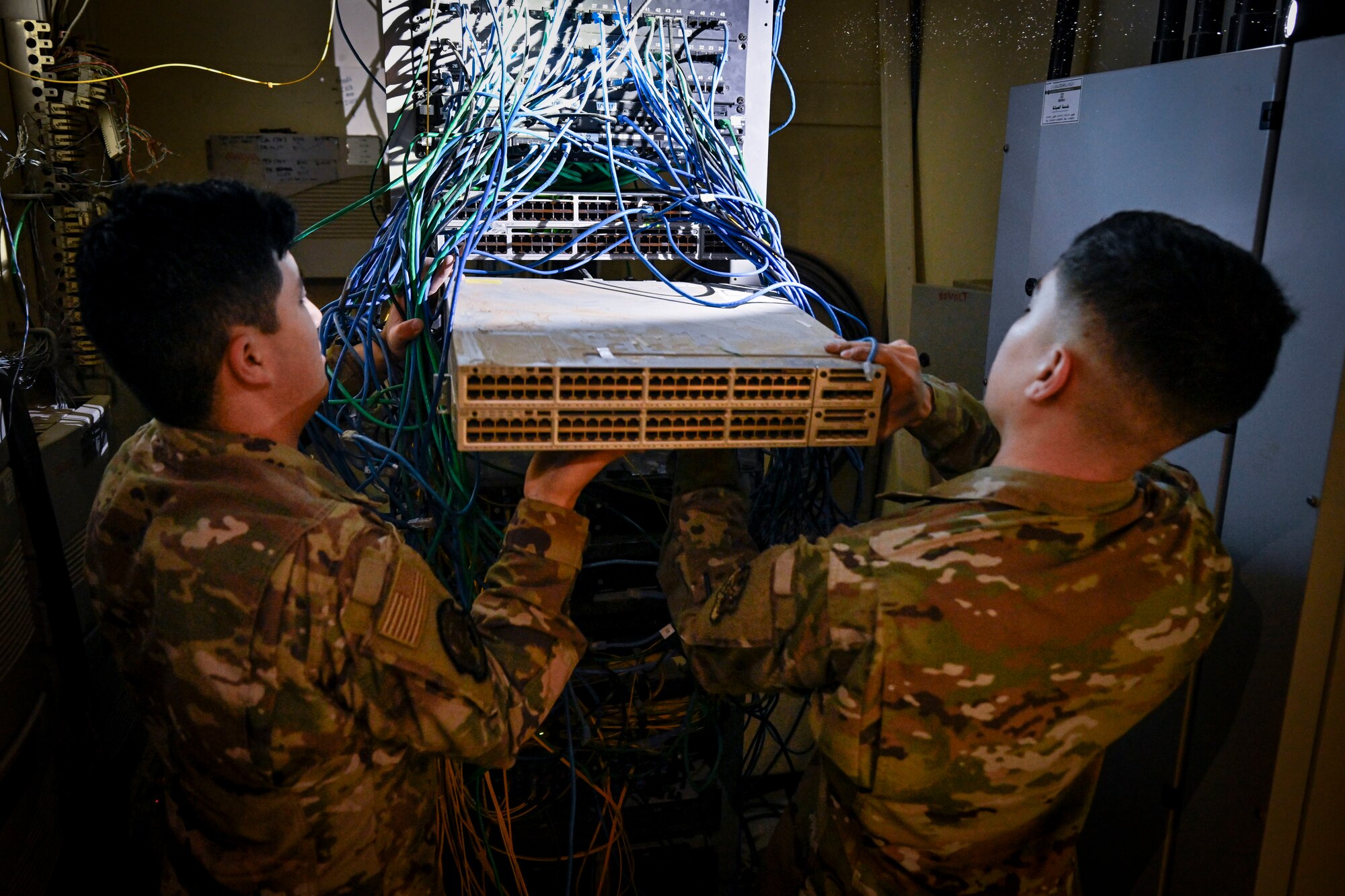 Two Airmen troubleshoot network connections.