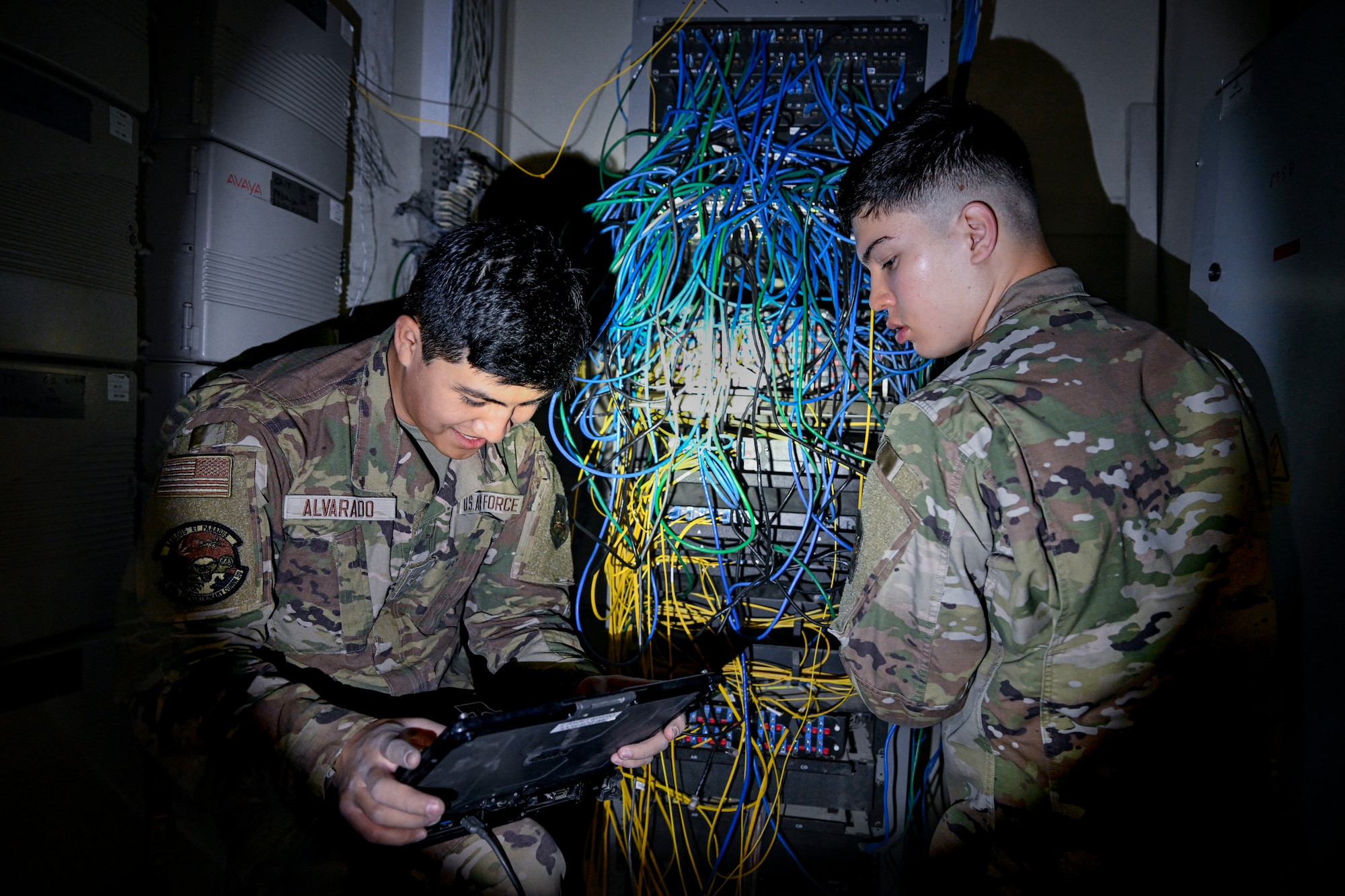 Two Airmen troubleshoot network connections.