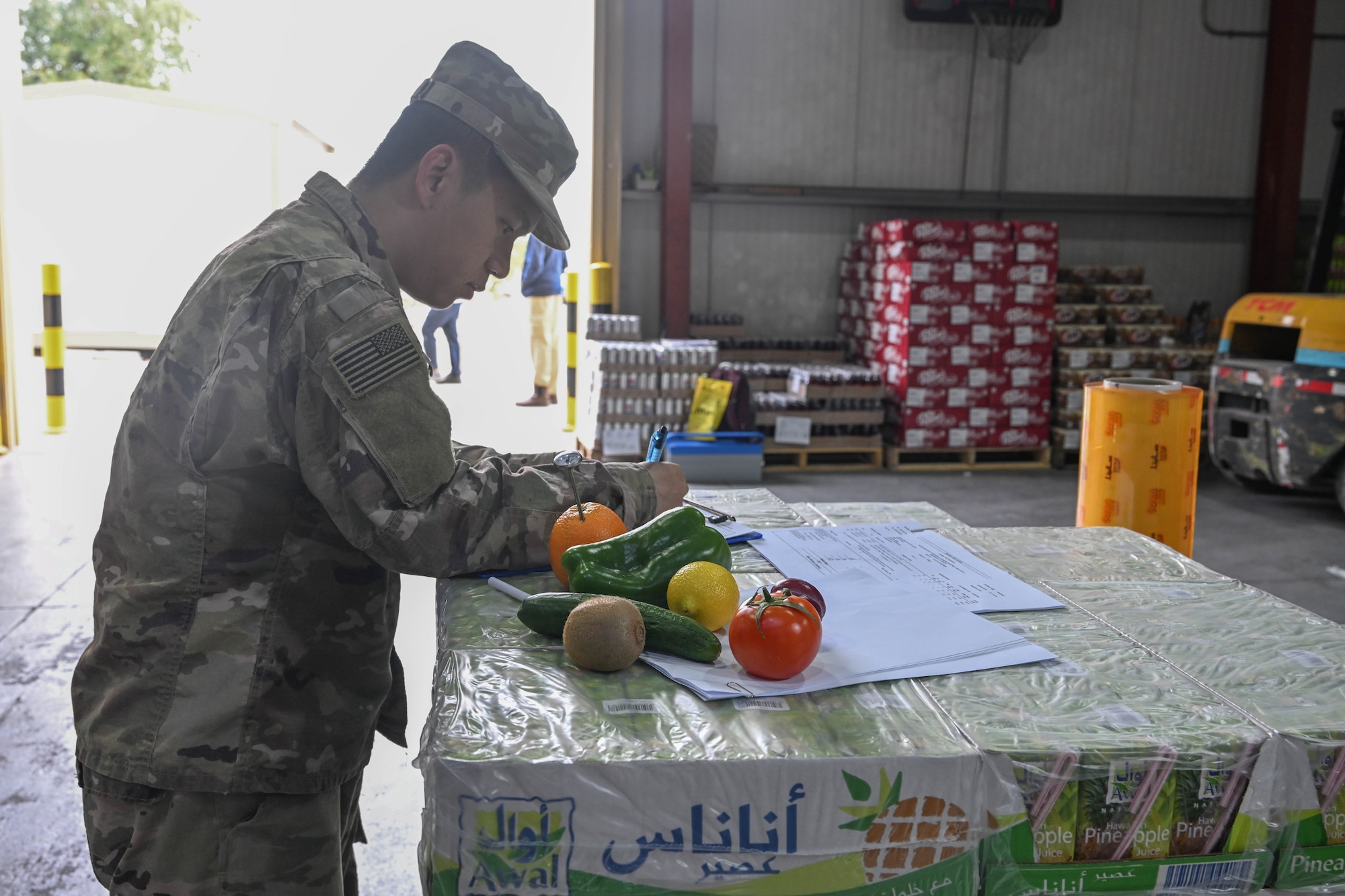 A man in uniform inspects fresh vegetables and fruits.
