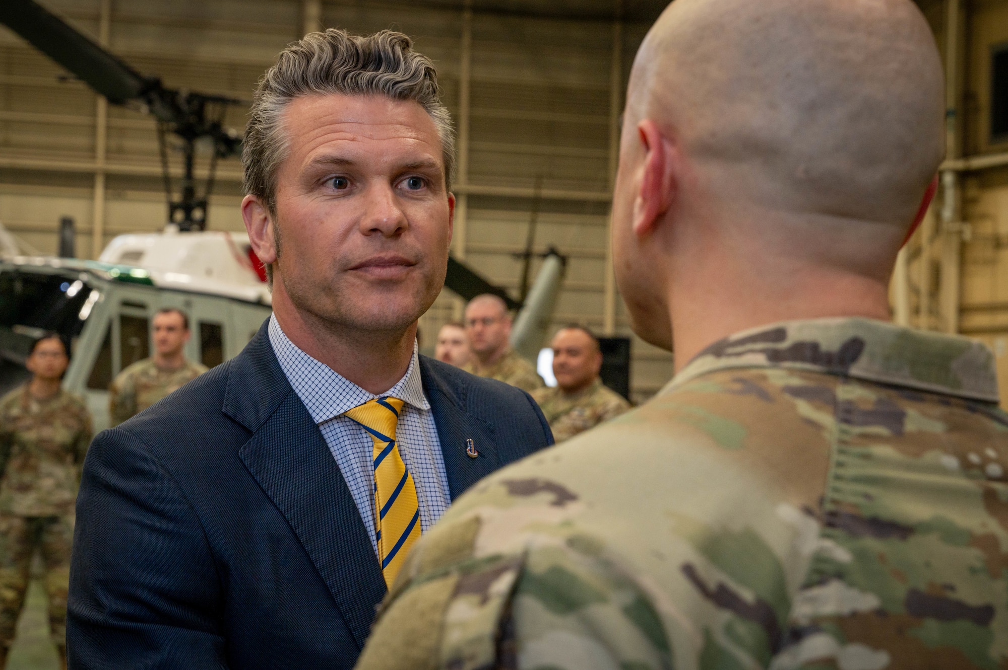 SECDEF rewards Airman with an appreciation coin during a troop talk event.