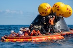 Sailors assigned to amphibious transport dock USS Somerset (LPD 25), Explosive Ordnance Disposal Group 1, Helicopter Sea Combat Squadron 23 “Wildcards,” and NASA personnel assist NASA Astronauts onto the “front porch,” an inflatable raft, during NASA Underway Recovery Test 12 in the Pacific Ocean, March 28, 2025.
