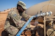 A Soldier receives a water sample from the improvised system
