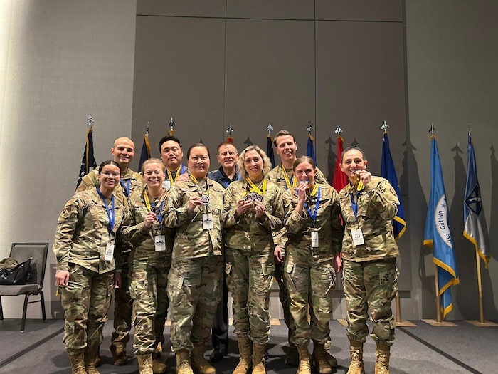Capt. Daniela Carchedi (bottom row, second from left) and fellow competitors celebrate their success at the 7th Annual Best Linguist Competition in Salt Lake City, Utah. The team, made up of individuals from diverse career fields, secured a second-place finish against trained cryptologic linguists, demonstrating the power of problem-solving under pressure. (Courtesy photo)